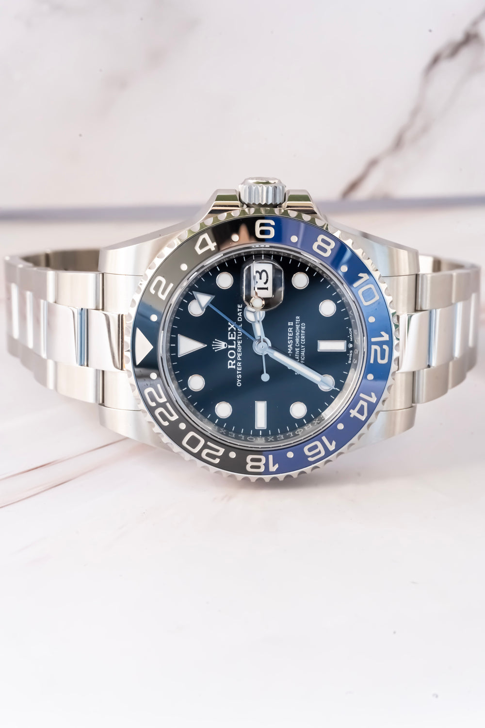 Rolex watch with blue bezel and face on a white background